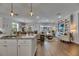 Spacious living room with hardwood flooring, open floor plan, and a view of the pool through sliding glass doors at 5026 Bromeliad Ave, Wimauma, FL 33598