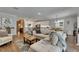 Inviting living room with hardwood floors, open to dining area and kitchen featuring a large sectional couch at 5026 Bromeliad Ave, Wimauma, FL 33598