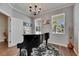 Elegant living area features a grand piano, natural light from two windows, and hardwood floors at 5026 Bromeliad Ave, Wimauma, FL 33598