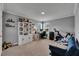Well-lit home office with ample desk space, shelving, and comfortable seating at 5026 Bromeliad Ave, Wimauma, FL 33598