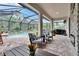 A covered outdoor living space with a pool, fireplace, comfortable seating, and a grill at 5026 Bromeliad Ave, Wimauma, FL 33598