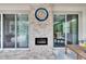 A travertine fireplace and flat screen TV between two sliding glass doors in a covered patio at 5026 Bromeliad Ave, Wimauma, FL 33598