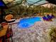 Screened-in pool features a sun shelf, water feature, patio loungers, and dining set at 5026 Bromeliad Ave, Wimauma, FL 33598
