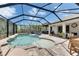 A large pool in screened patio with jacuzzi and dining area at 5026 Bromeliad Ave, Wimauma, FL 33598