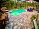 A screened-in pool with a sun shelf, water feature, patio loungers, and dining set at 5026 Bromeliad Ave, Wimauma, FL 33598