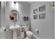 Elegant powder room features a pedestal sink, starfish art, and a modern toilet at 5026 Bromeliad Ave, Wimauma, FL 33598