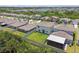 Aerial view of backyard featuring a well-maintained lawn, privacy fence, and covered patio, creating an ideal outdoor living space at 5410 Amaryllis Garden St, Apollo Beach, FL 33572