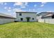 Sprawling backyard with green grass, enclosed by a white fence, providing a secure and spacious outdoor area for leisure and play at 5410 Amaryllis Garden St, Apollo Beach, FL 33572