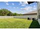Spacious backyard featuring lush green grass, privacy fence, and air conditioning units at 5410 Amaryllis Garden St, Apollo Beach, FL 33572