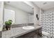 Modern bathroom features granite counters, sleek fixtures, and a stylish shower curtain, exuding elegance at 5410 Amaryllis Garden St, Apollo Beach, FL 33572