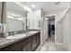 Bathroom with double vanity, granite countertop, and walk-in shower at 5410 Amaryllis Garden St, Apollo Beach, FL 33572