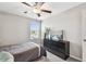 Bedroom featuring a ceiling fan, dresser, and natural light from a large window at 5410 Amaryllis Garden St, Apollo Beach, FL 33572
