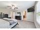 Bedroom features a ceiling fan, carpet flooring, and access to an ensuite bathroom at 5410 Amaryllis Garden St, Apollo Beach, FL 33572