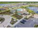 Aerial view of a community clubhouse with a pool, lounge chairs, and beautiful landscaping by a lake at 5410 Amaryllis Garden St, Apollo Beach, FL 33572