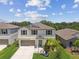 Charming two-story home with a well-manicured lawn and inviting curb appeal, highlighted by blue shutters and a light blue front door at 5410 Amaryllis Garden St, Apollo Beach, FL 33572