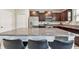 A kitchen island features seating and granite countertops, with stainless steel appliances and dark wood cabinets at 5410 Amaryllis Garden St, Apollo Beach, FL 33572