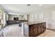 The kitchen island has cabinets and drawers and granite countertops overlooking the dining and living areas at 5410 Amaryllis Garden St, Apollo Beach, FL 33572