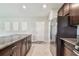 A kitchen features stainless steel appliances, granite countertops, dark wood cabinets, and tile flooring at 5410 Amaryllis Garden St, Apollo Beach, FL 33572