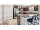 A kitchen features a large granite island with seating, stainless steel appliances, and dark wood cabinets at 5410 Amaryllis Garden St, Apollo Beach, FL 33572