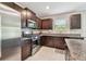 A kitchen features stainless steel appliances, granite countertops, dark wood cabinets, and a stainless steel microwave at 5410 Amaryllis Garden St, Apollo Beach, FL 33572