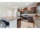 The kitchen features an island with seating, tile floors, stainless steel appliances, and dark wood cabinets at 5410 Amaryllis Garden St, Apollo Beach, FL 33572