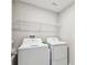 Functional laundry room with modern appliances and shelving, offers convenience and efficiency at 5410 Amaryllis Garden St, Apollo Beach, FL 33572