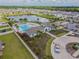 Aerial view showcasing a community pool, clubhouse, playground, lake, and manicured landscaping at 5410 Amaryllis Garden St, Apollo Beach, FL 33572