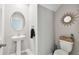 Elegant powder room featuring a pedestal sink, decorative mirror, and modern fixtures at 5410 Amaryllis Garden St, Apollo Beach, FL 33572