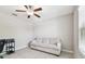 The room is bright with a ceiling fan and tile flooring with an off white sofa at 5410 Amaryllis Garden St, Apollo Beach, FL 33572