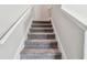 A staircase features gray carpeting and white walls leading to the upper level of the home at 5410 Amaryllis Garden St, Apollo Beach, FL 33572