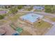 Aerial view of a single-story home with a metal roof, chain link fence, and spacious yard at 5432 Queen Ave, Spring Hill, FL 34609