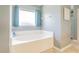 Bright bathroom with large soaking tub, window and neutral walls at 5432 Queen Ave, Spring Hill, FL 34609