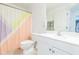 Bright bathroom featuring a white vanity and a colorful, geometrically patterned shower curtain at 5432 Queen Ave, Spring Hill, FL 34609