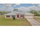 Inviting single-story home featuring a metal roof, double door entry, and attached two car garage at 5432 Queen Ave, Spring Hill, FL 34609