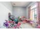 Play room with tile floors, lots of toys, and a large window with curtains at 5432 Queen Ave, Spring Hill, FL 34609