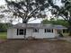 Well-maintained home featuring a metal roof, crisp white siding, and a covered side entrance at 5535 Peach Ave, Seffner, FL 33584