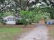 A charming home and two outbuildings surrounded by lush greenery create a private, serene setting at 5535 Peach Ave, Seffner, FL 33584