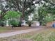 A cozy home and multiple outbuildings can be found surrounded by large trees and a driveway at 5535 Peach Ave, Seffner, FL 33584