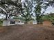 Charming house and detached garage with a metal roof surrounded by mature shade trees at 5535 Peach Ave, Seffner, FL 33584