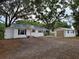 Charming home with white siding, black shutters, metal roof, and detached garage at 5535 Peach Ave, Seffner, FL 33584