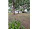 Lush front yard with mature trees and a charming swing and flower garden at 5535 Peach Ave, Seffner, FL 33584