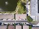 Overhead view of townhomes near a lake featuring walking path and fountain, surrounded by lush greenery at 8181 Eagles Park N Dr, St Petersburg, FL 33709