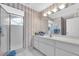 Bathroom with a spacious vanity and a walk-in shower with a glass door and tile flooring at 8181 Eagles Park N Dr, St Petersburg, FL 33709
