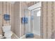 Cozy bathroom featuring a shower with glass door, toilet, and blue accents at 8181 Eagles Park N Dr, St Petersburg, FL 33709