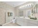 Bathroom featuring floral wallpaper, a shower, a large mirror, and a dual sink vanity at 8181 Eagles Park N Dr, St Petersburg, FL 33709