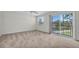 Spacious bedroom featuring carpet, a ceiling fan, and large sliding glass doors with a water view at 8181 Eagles Park N Dr, St Petersburg, FL 33709