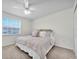 Spacious bedroom featuring a large window, ceiling fan, and comfortable carpet at 8181 Eagles Park N Dr, St Petersburg, FL 33709