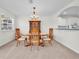 An eat in dining area is presented with dark wood furniture and light, neutral carpeting and walls at 8181 Eagles Park N Dr, St Petersburg, FL 33709