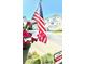 Charming two-story home with well-manicured landscaping, an American flag, and visible 'For Sale' sign at 8181 Eagles Park N Dr, St Petersburg, FL 33709