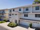 Charming townhome with a white exterior, well-manicured landscaping, and a two-car garage at 8181 Eagles Park N Dr, St Petersburg, FL 33709